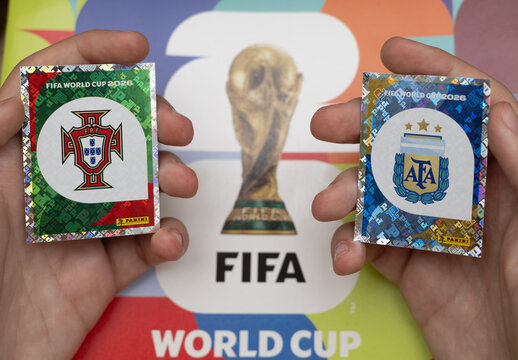 hands holding shiny panini stickers of portugal and argentina football national crests for the fifa world cup 2026 tournament background