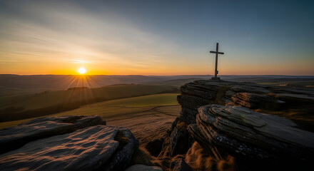 Obraz premium Christian cross standing on rocky mountain top at sunrise with mountain religion christianity