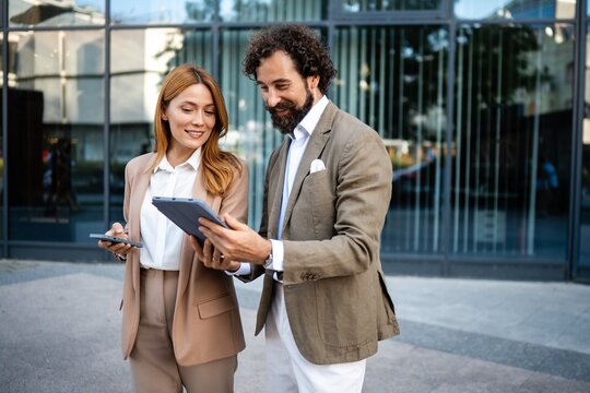 Business people using digital tablet and smartphone outdoors