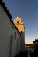 Fototapeta premium White Stucco Mission-Style Church Tower with Cross and Tiled Roof