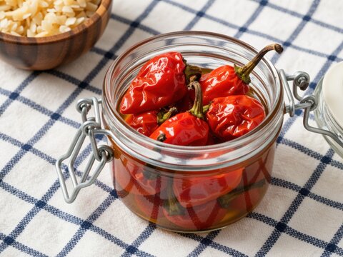 Preserving red chili peppers in olive oil glass jar
