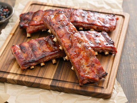 Glazed barbecue pork ribs serving on wooden board