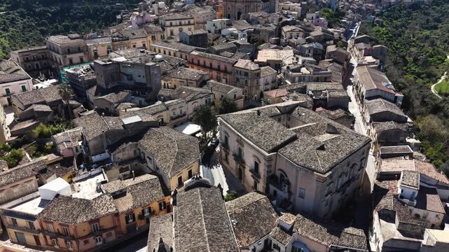 Aerial view of the historic stone buildings and terracotta tiled rooftops in the old town of Ragusa, Sicily, Italy.