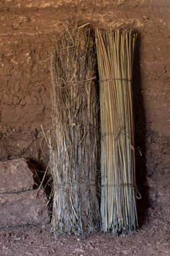 Primitive rolled mats leaning against adobe wall