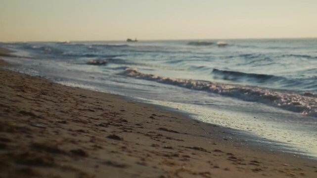 Small sea wave, Blurred Soft foamy waves washing golden sandy beach dawn. Ocean Waves Sandy Beach. Nobody. Holiday recreation concept. Abstract nautical summer ocean sunset nature background. Static