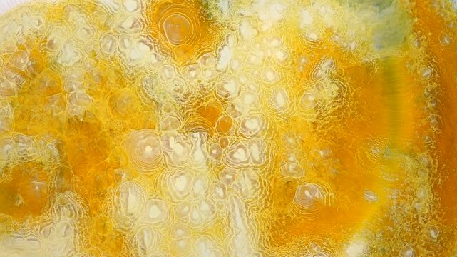 Alcohol ink on canvas shows swirling patterns in yellow and white during a studio art session