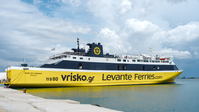 Large yellow ferry at dock under cloudy sky
