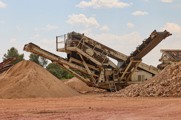 Fototapeta premium Industrial crushing machine processing aggregates in quarry site