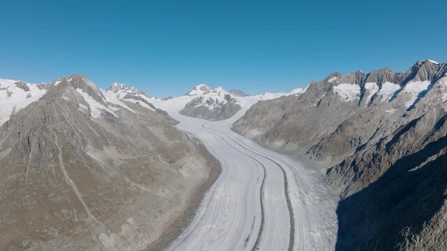 Aerial drone view of Aletsch Glacier in Switzerland. Frozen ice texture, crevasses, and alpine nature landscape from above. Melting glaciers. Global warming.