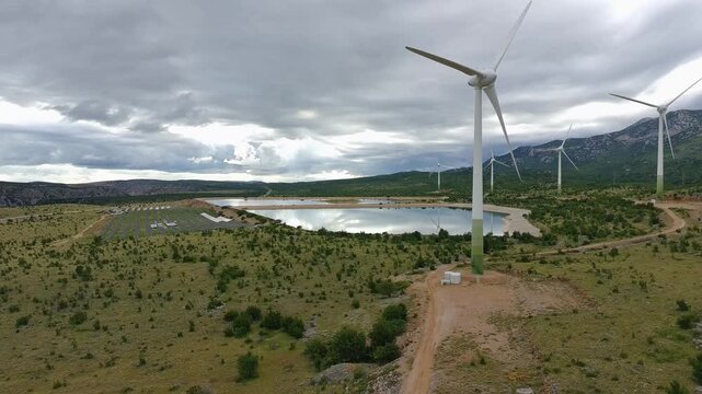 Drone video of Wind Turbines Turning on a Mountain with a Sky Background. Concept of Environmental Conservation, Wind farm