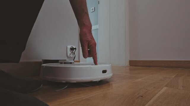 Senior Man Activating Robotic Vacuum Cleaner at Home
