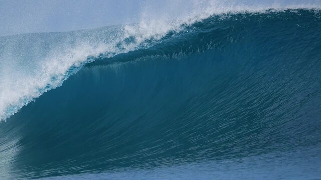 CLOSE UP, SLOW MOTION: Heavy blue wall of water rising at Mentawai reef break. Big barrelling wave and exploding whitewater. Nature scenery shaped by offshore breeze and reef beneath the ocean surface