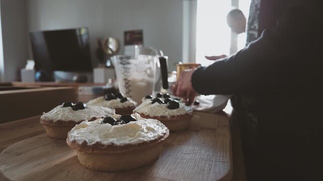Senior woman preparing fresh fruit cakes in the kitchen
