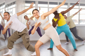 Obraz premium Group of multiethnic men and women rehearsing hip hop dance in studio