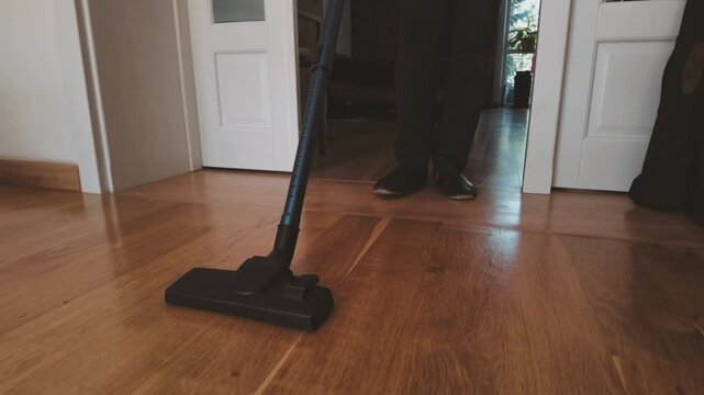 Senior Man Vacuuming Floor at Home
 