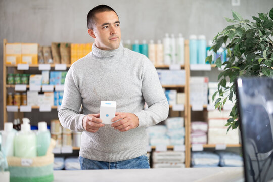 Male buyer buys medicinal ointment at a pharmacy