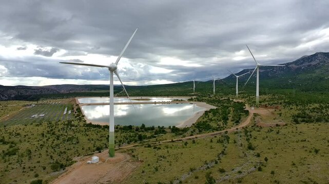 Drone video of Wind Turbines Turning on a Mountain with a Sky Background. Concept of Environmental Conservation, Wind farm