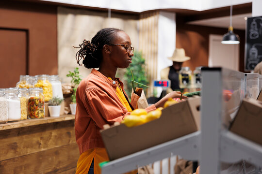 African American female customer in a grocery store. She browses organic vegetables, grains, and sustainable products. The store offers locally grown, zero-waste items. Foreground focus.