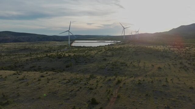 Drone video of Wind Turbines Turning on a Mountain with a Sky Background. Concept of Environmental Conservation, Wind farm