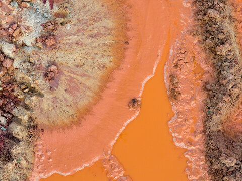 Aerial view of orange clay soil and muddy textures at an excavation site in Coimbra, Coimbra District, Portugal.