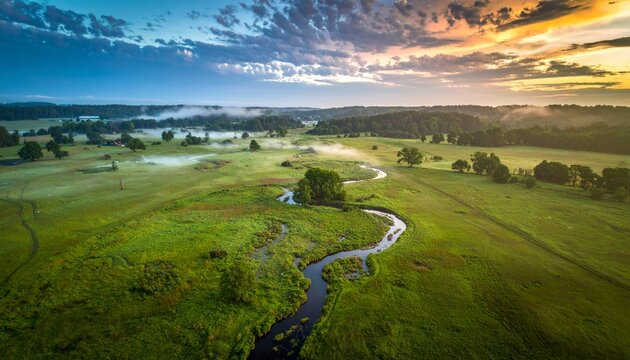 Golden Sunrise Over a Serpentine River in a Vast, Misty Green Valley