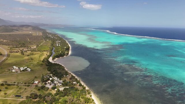 Aerial turquoise lagoon coastline in New Caledonia showcasing coral reef patches, shallow turquoise waters, the longest barrier reef in the world New Caledonia.