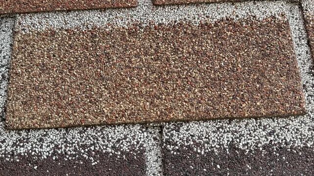 Facade tiles closeup textured brown brick showing granular surface and mortar lines tight framing reveals repeating rectangular