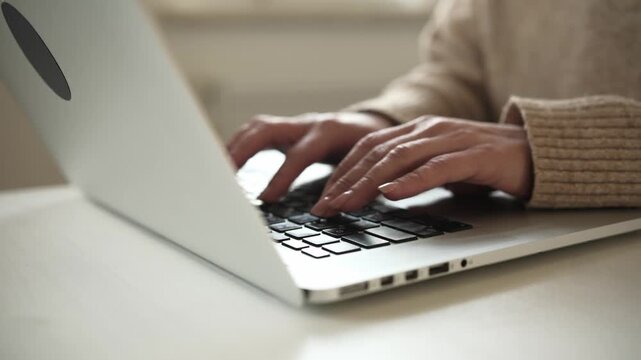 Female Hands Typing Text On A Laptop Keyboard On A Table In The Living Room
