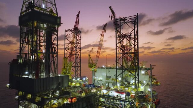 Aerial view of offshore jack up rig and offshore platform during sunset for oil and gas exploration and production. 