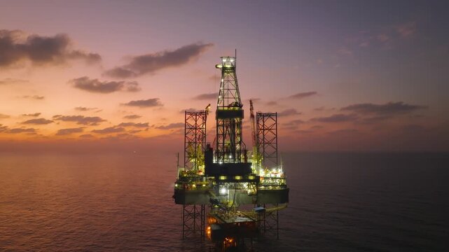 Aerial view of offshore jack up rig and offshore platform during sunset for oil and gas exploration and production. 