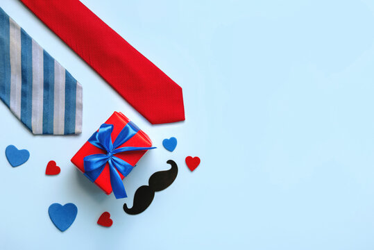 Happy Father's Day. Top view of red gift pack with hearts,neckties and mustache with space for text