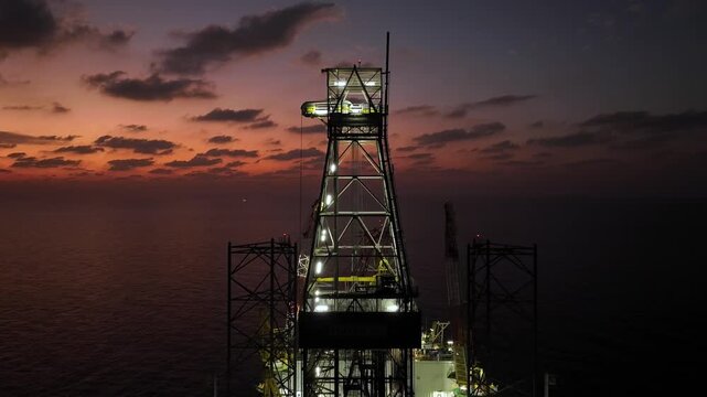 Aerial view of offshore jack up rig and offshore platform during sunset for oil and gas exploration and production. 