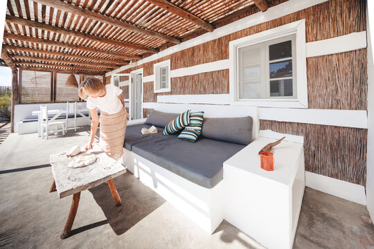 Woman placing pastry on rustic table on outdoor patio
