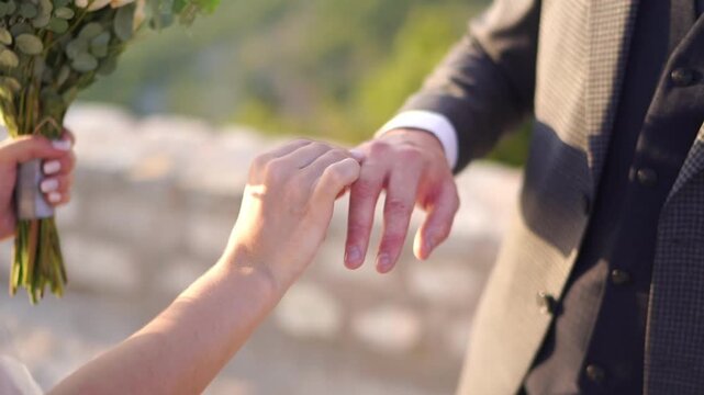 Intimate vow exchange captured with gentle hand hold at sunset on terrace