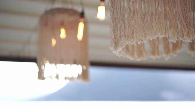 Coastal fringe chandelier casting gentle light over evening water scene