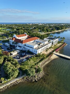 Palm Beach, United States - 03 June 2026: Aerial view of the historic Henry Morrison Flagler Museum with its red-tiled roofs and lush grounds along the waterfront under a clear blue sky.