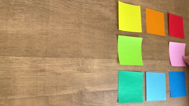 Child Hand Arranging the Eighth Small Pink Origami Paper in an Ordered Grid from an Overhead View, 4K Slow Motion Silent Video