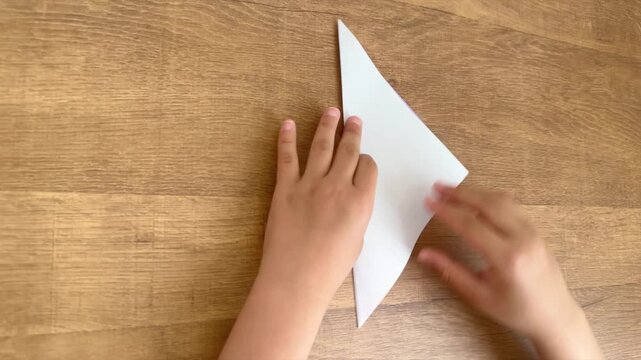Child Hands Opening a Light Purple Origami Paper After a Triangle Fold to Show the Crease, 4K Silent Video