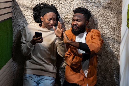 Top down of black people arguing laid back on hallway floor at home, engaged in a loud heated argument, Man and woman look frustrated and unhappy, showcasing relationship drama.