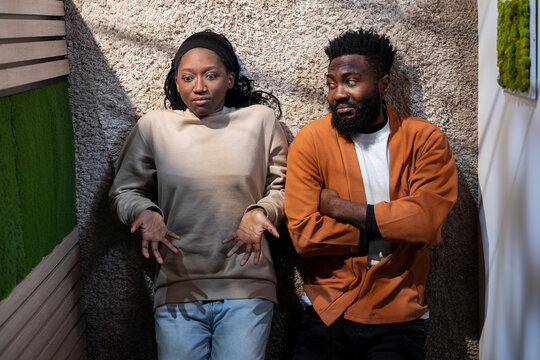 Top down of African American couple fighting in a hallway at home, engaged in a loud domestic quarrel, Man and woman look enraged, frustrated and unhappy, showing relationship conflict.