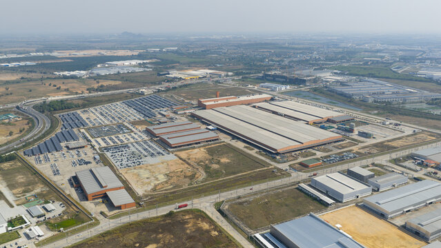 Khao Khansong, Thailand - 11 February 2026: Aerial view of MG PDC Chonburi automotive factory with large warehouses, parking lots filled with vehicles, and solar panel installations.