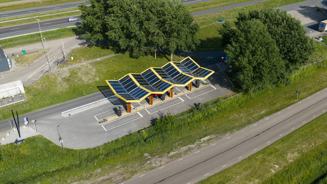 Darp, Netherlands - 23 May 2026: Aerial drone view of a Fastned fast charging station along the highway, showing DC EV charging, electric mobility, clean transport and highway infrastructure.