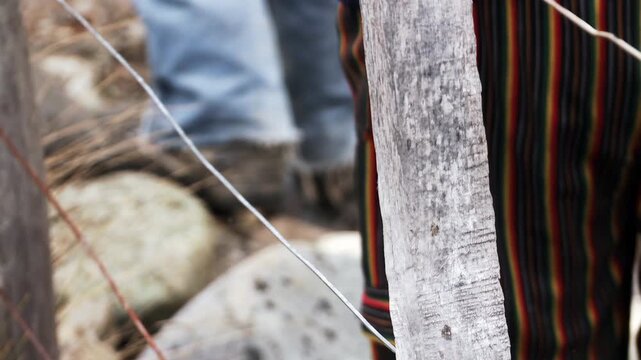 Close Up of Person Wearing Traditional Striped Fabric Passing Through Farm Gate - 4K