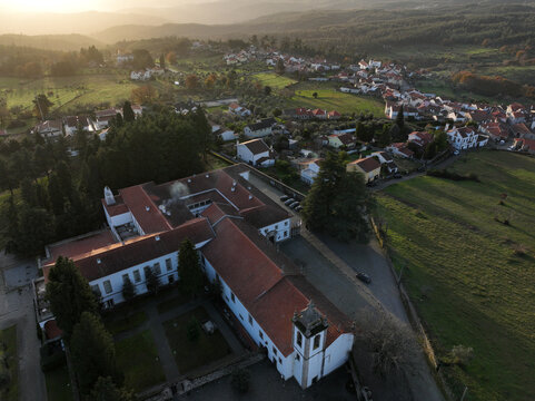 Vila Pouca da Beira, Portugal - 31 December 2023: Aerial view of Lam Hotel Convento do Desagravo with its red-tiled roofs and bell tower overlooking the village and hazy hills.