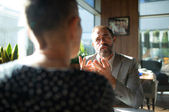 Mature businessman consulting client in modern cafe