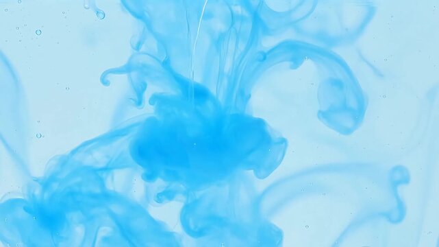 Abstract blue ink swirling in clear water, creating a mesmerizing cloud-like diffusion pattern