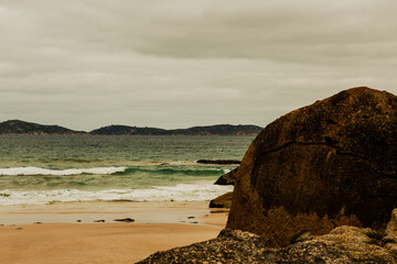Large granite boulder on sandy beach coastal wilderness exploration © Sam