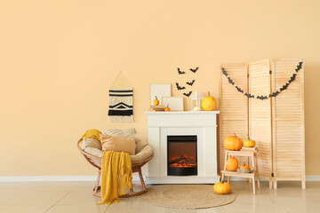 Obraz premium Interior of living room decorated for Halloween with fireplace, armchair and folding screen