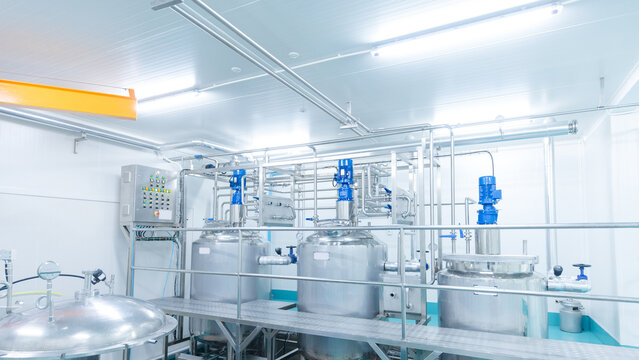 Modern stainless steel processing tanks automated mixing system inside hygienic food manufacturing facility industrial production equipment safe quality control efficient large scale operations.