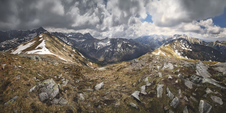 View of Kasprowy Wierch with rugged mountain peaks, patches of snow on the slopes, and a dramatic cloudy sky in the Tatra Mountains Zakopane, Lesser Poland, Poland.